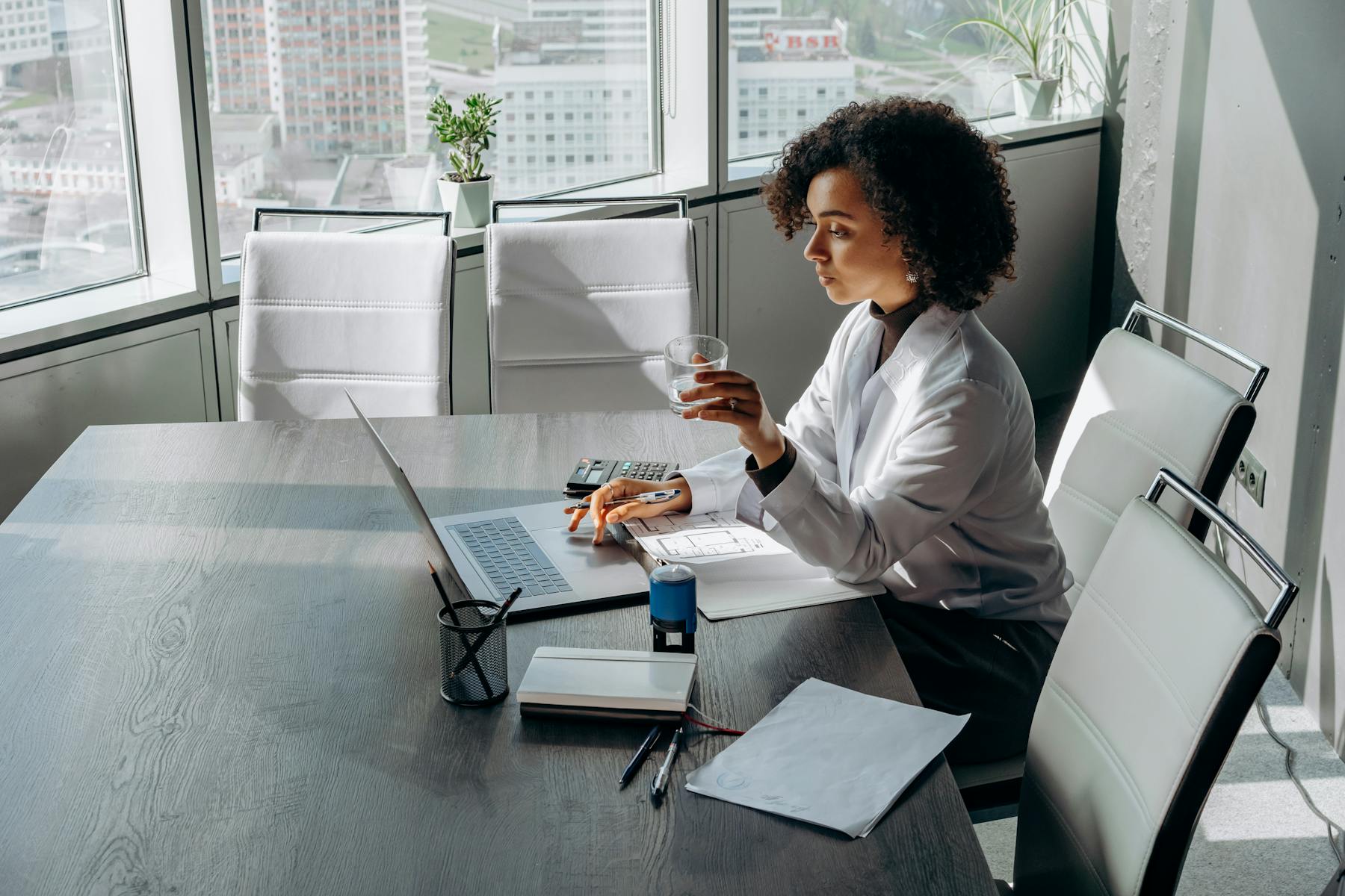 Professional using a laptop in a bright meeting room